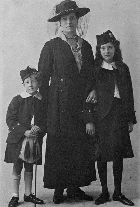 Photo of Sir Patrick to the left of his mother, his sister to the right, all standing
    