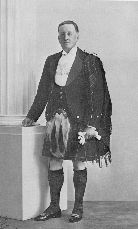 Photo of Sir Trevor Ogilvie-Grant in a kilt beside a white column
    