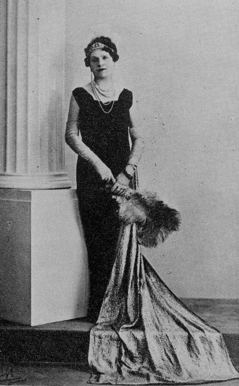 Photo of a Alice Louisa in an evening dress beside a white column
    
